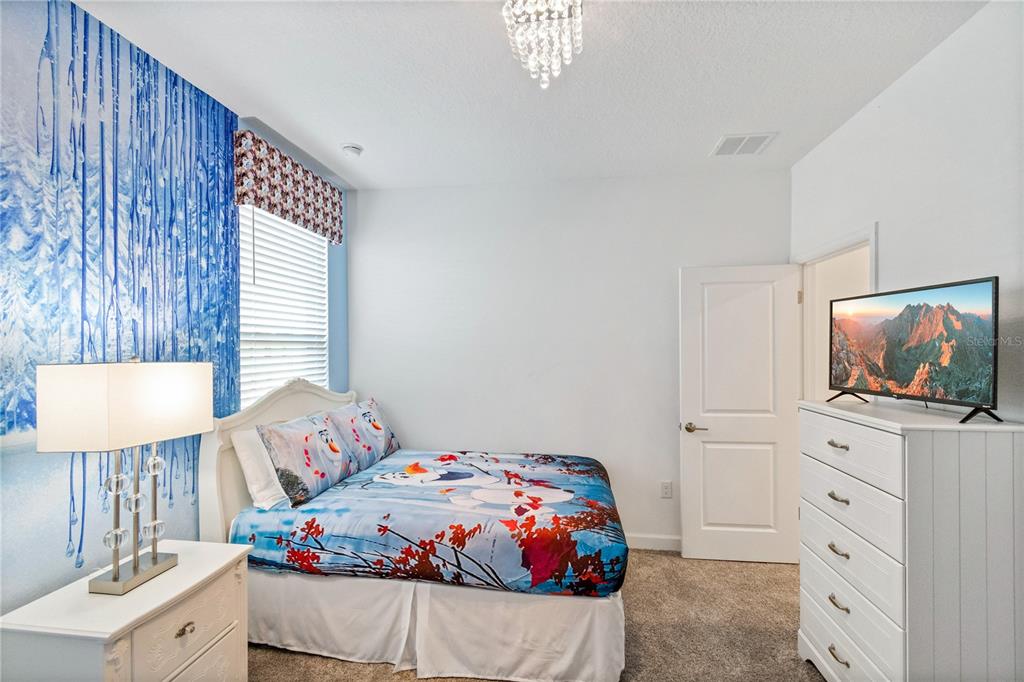 3032 Protagonist Street Kissimmee, FL 34746 - Photo 29 of 34 a bedroom with a bed and flat screen tv