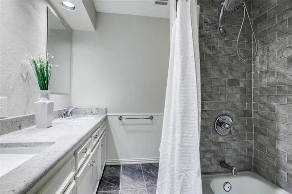a bathroom with a granite countertop sink a toilet and shower