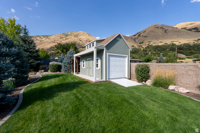 687 South 2080th Street East Springville, UT 84663 - Photo 109 of 149 Stand-alone structure featuring a gable roof, light green siding, and a white garage door with a ramp