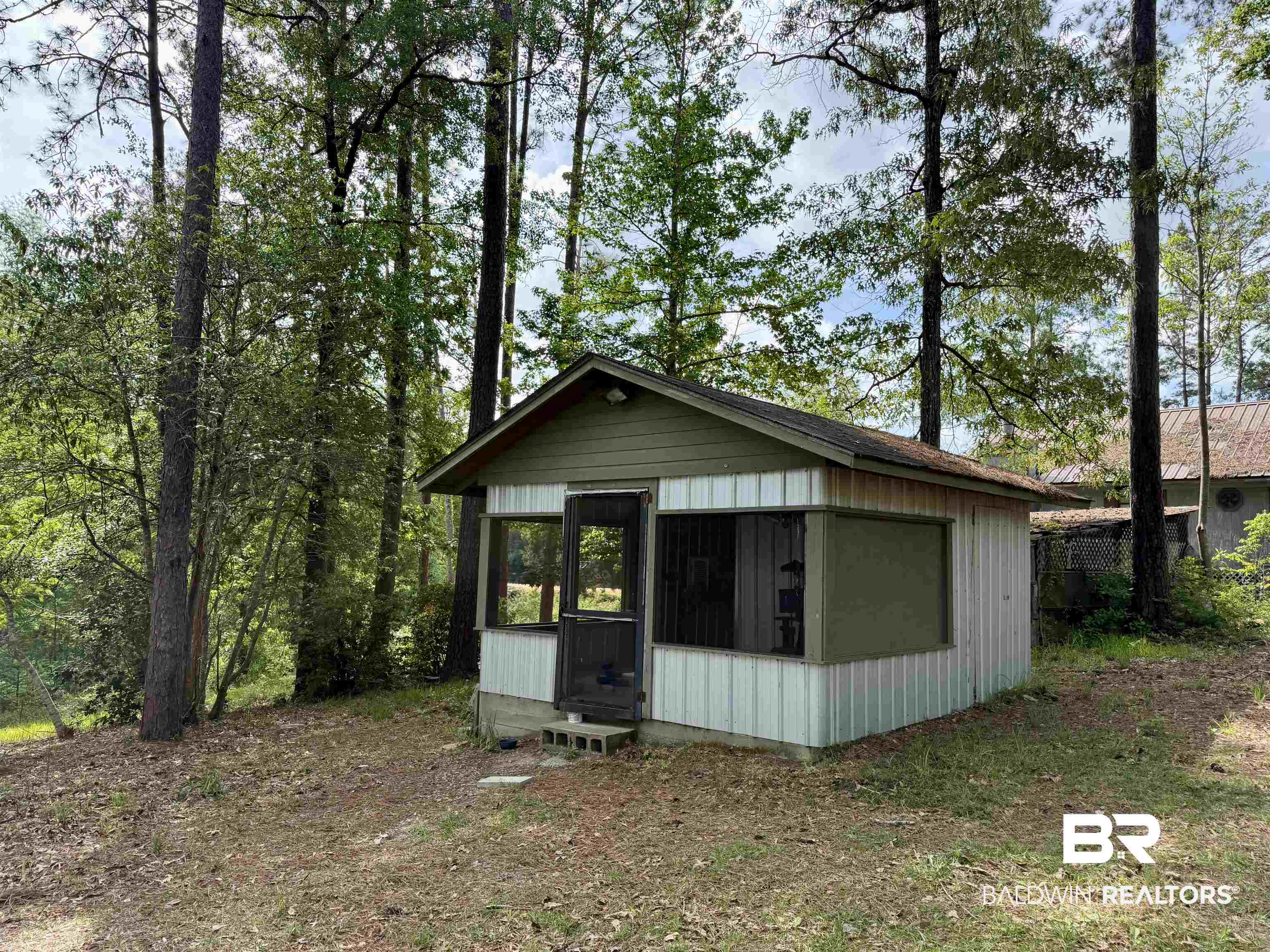 762 Buddy Lake Road Brewton, AL 36426 - Photo 19 of 20 Wooded lot featuring an auxiliary structure with a screened porch and multiple windows