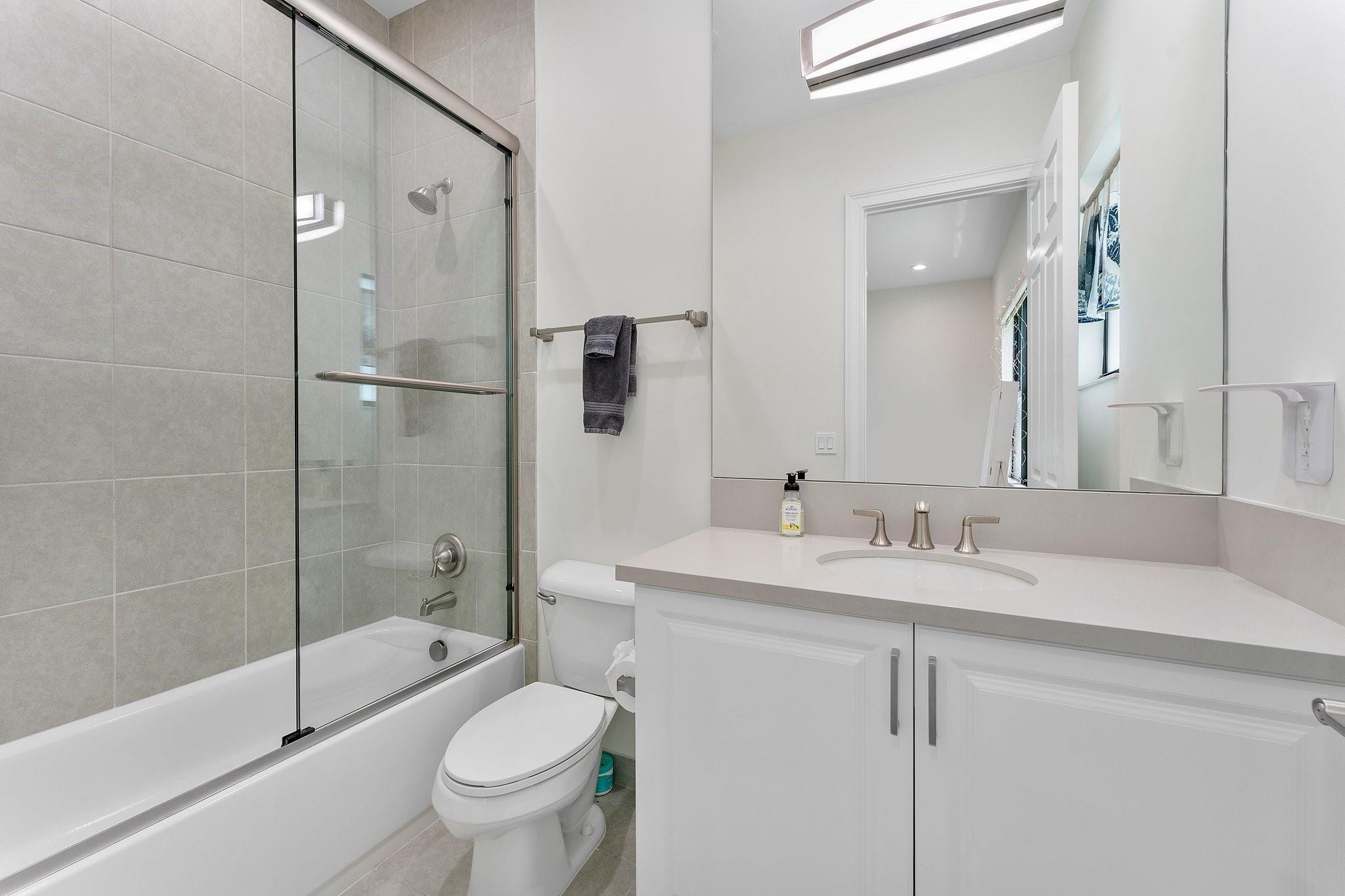 9626 Vescovato Way Boca Raton, FL 33496 - Photo 25 of 72 a bathroom with a granite countertop sink toilet mirror and shower