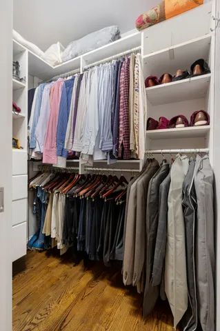 a view of walk in closet with clothes and shoes