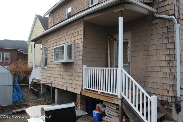 a view of a house with a deck and furniture