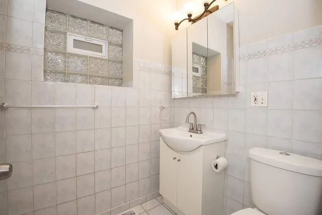 a bathroom with a sink mirror and toilet