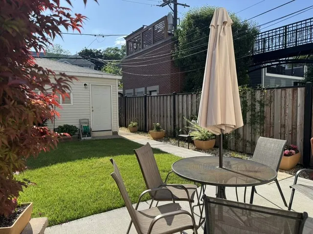 a view of a chair and table in backyard of the house
