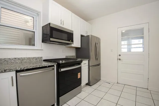 a kitchen with granite countertop a refrigerator and a stove