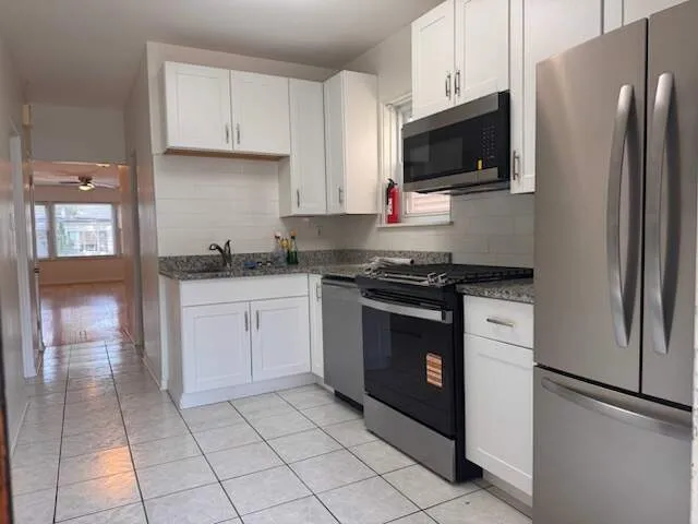 a kitchen with stainless steel appliances granite countertop a refrigerator stove and sink