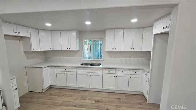 a kitchen with a sink a window and cabinets