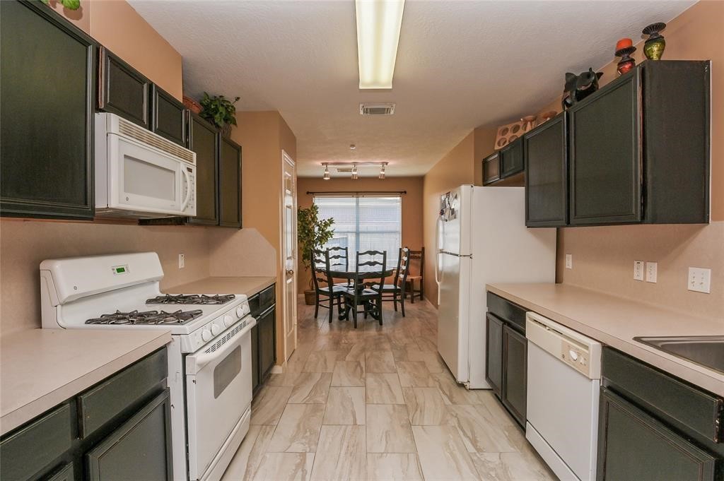 18446 South Wimbledon Drive Katy, TX 77449 - Photo 16 of 24 a kitchen with granite countertop a stove a sink dishwasher a refrigerator with wooden floor