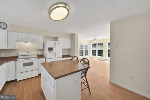 a kitchen with a table chairs a stove and a wooden floor