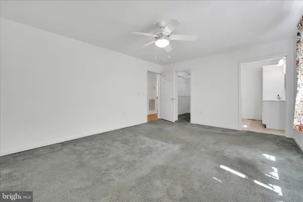 a view of an empty room with a chandelier fan