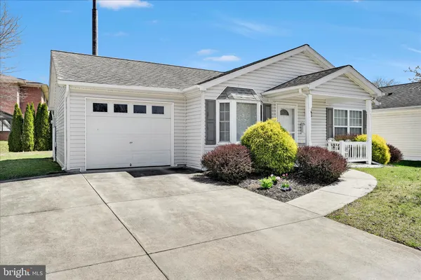 a view of a house with a small yard and a large tree
