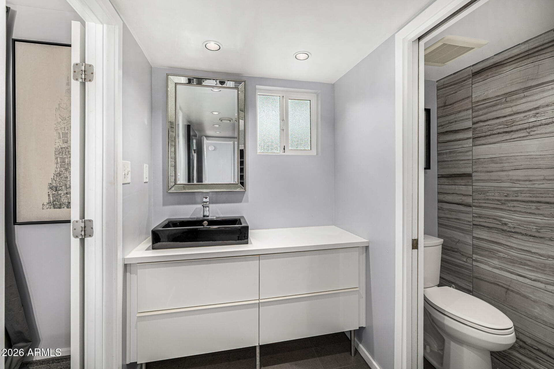 1107 West Osborn Road, Unit 118 Phoenix, AZ 85013 - Photo 12 of 18 a bathroom with a toilet a sink and mirror