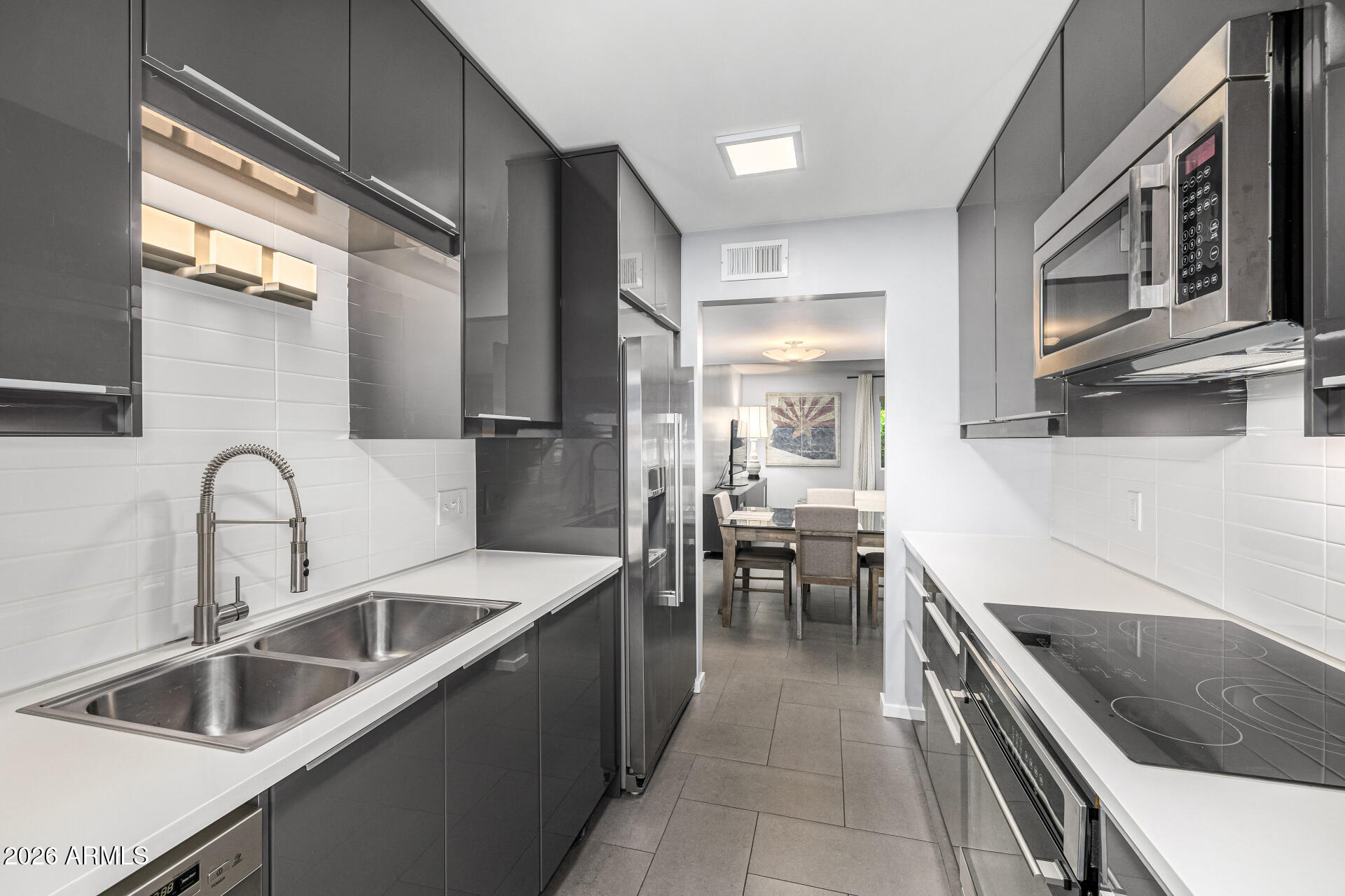 1107 West Osborn Road, Unit 118 Phoenix, AZ 85013 - Photo 5 of 18 a kitchen with granite countertop a sink a counter top space stainless steel appliances and cabinets