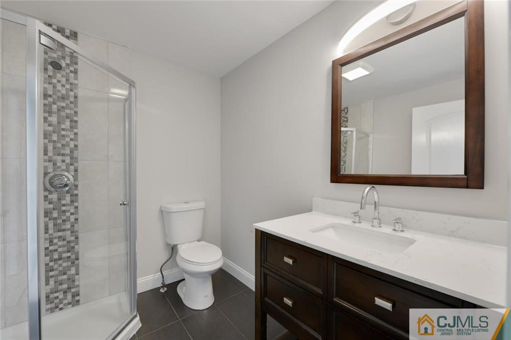 18 Old Ridge Road Monmouth Junction, NJ 08852 - Photo 17 of 25 a bathroom with a sink a toilet and a large mirror