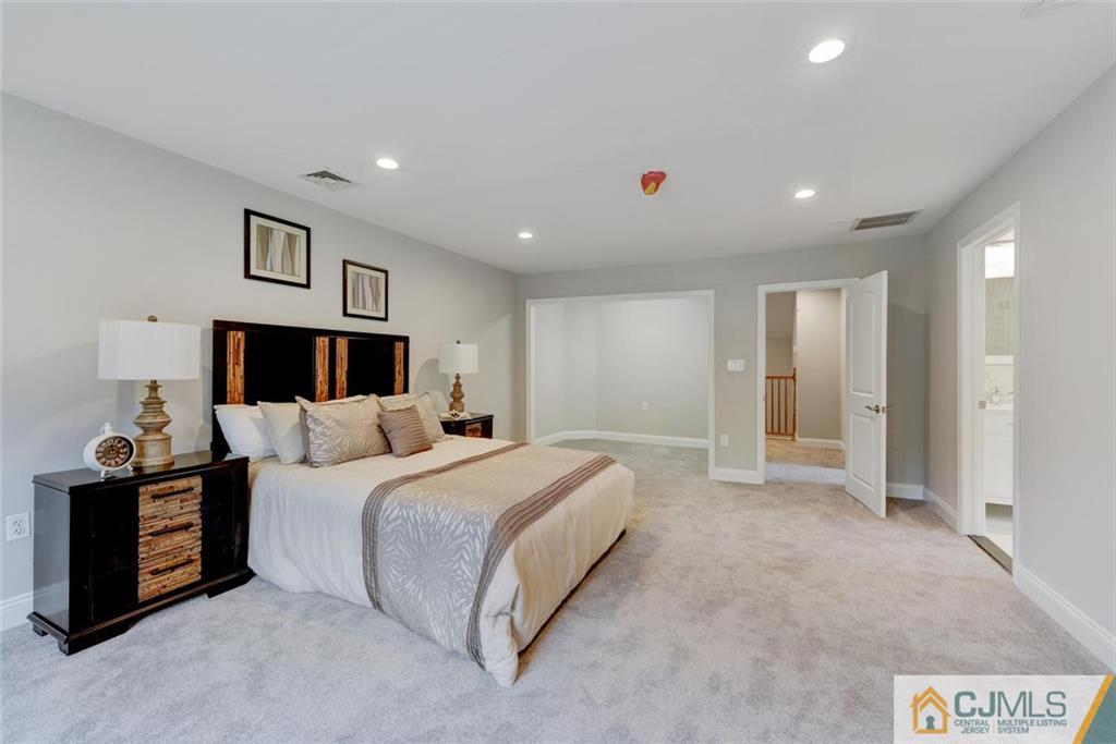18 Old Ridge Road Monmouth Junction, NJ 08852 - Photo 22 of 25 a spacious bedroom with a large bed and a chandelier