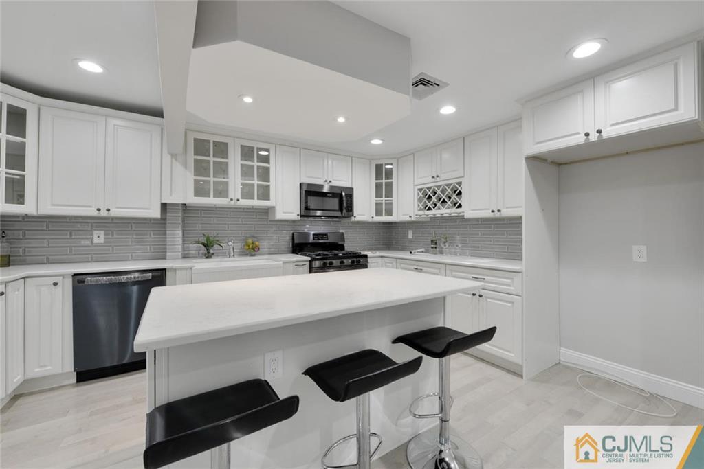 18 Old Ridge Road Monmouth Junction, NJ 08852 - Photo 6 of 25 a kitchen with stainless steel appliances kitchen island a sink a stove a refrigerator and cabinets