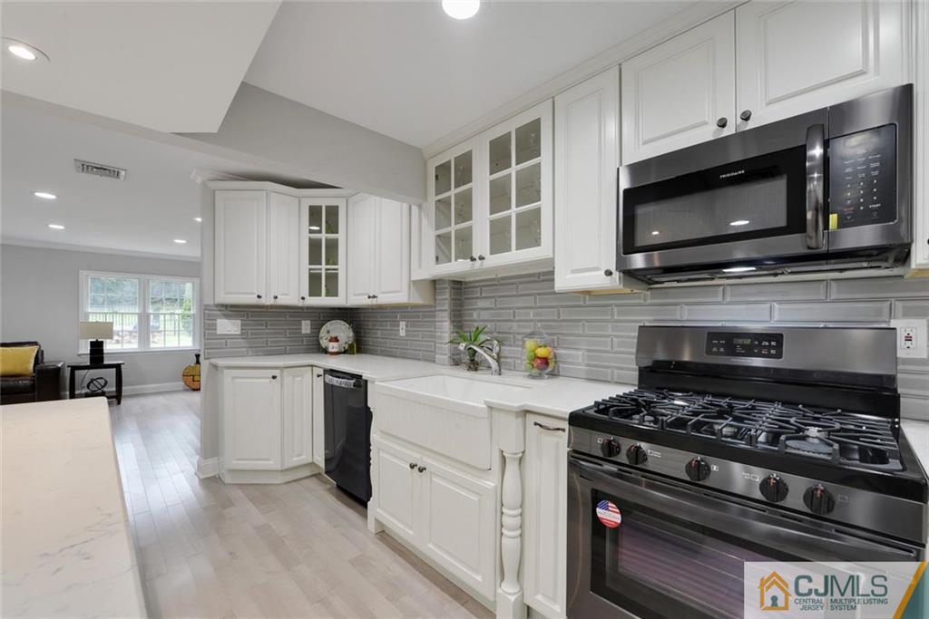 18 Old Ridge Road Monmouth Junction, NJ 08852 - Photo 9 of 25 a kitchen with stainless steel appliances a stove a microwave a sink and cabinets
