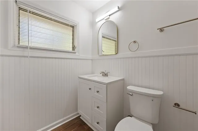 a bathroom with a toilet a sink and mirror