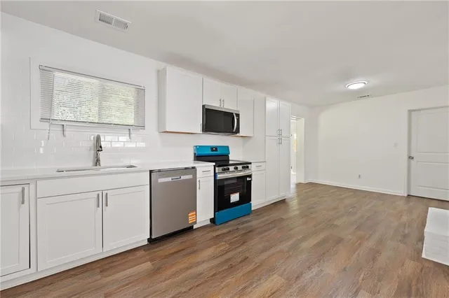 a kitchen with sink stove and refrigerator