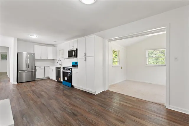 a view of kitchen with wooden floor and electronic appliances