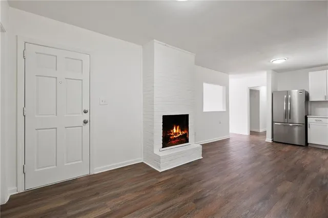 a view of a kitchen with a sink a fireplace and wooden floor