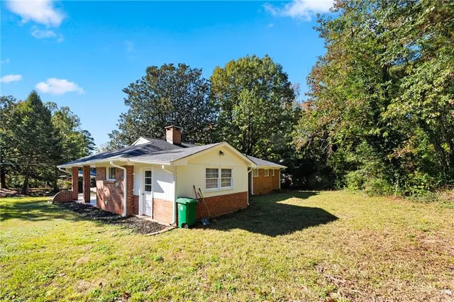 a front view of a house with a yard covered with snow