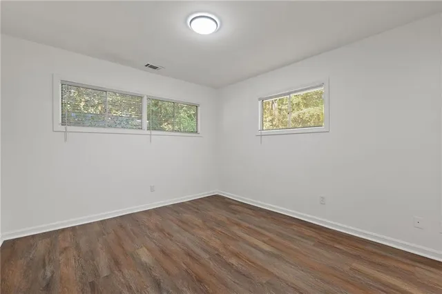 an empty room with wooden floor and window