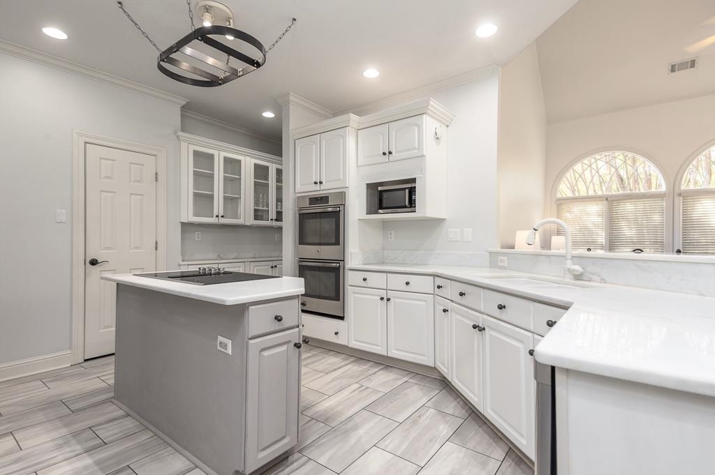 1893 Hartwell Manor West Collierville, TN 38017 - Photo 12 of 40 Kitchen with white cabinetry, glass insert cabinets, stainless steel appliances, a kitchen island, and ornamental molding