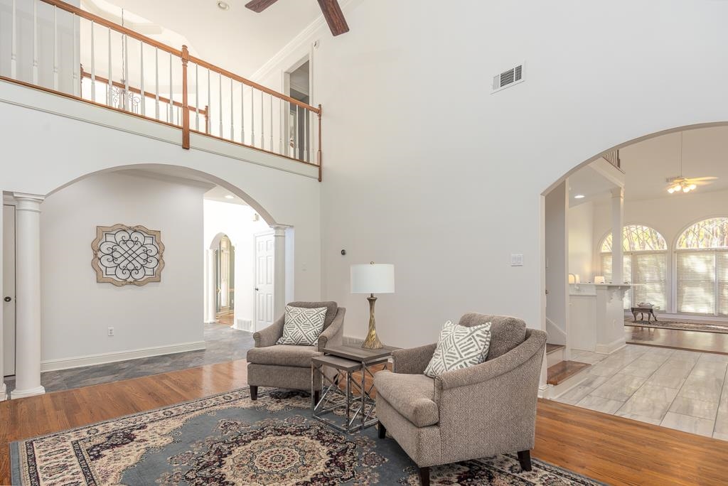 1893 Hartwell Manor West Collierville, TN 38017 - Photo 9 of 40 Living room featuring a ceiling fan, arched walkways, wood finished floors, decorative columns, and a high ceiling
