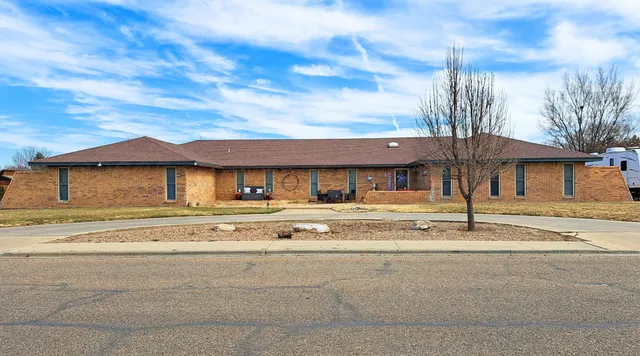 a view of a house with a big yard and large tree