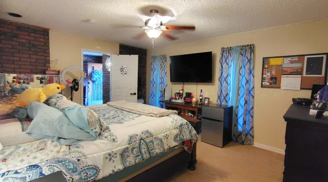 a bedroom with a bed and a flat tv screen on dresser