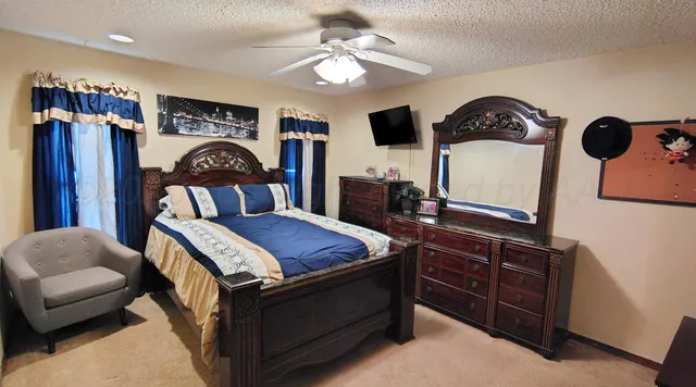 a bedroom with a bed a chandelier and dresser
