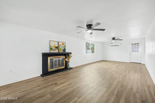 a view of a room with wooden floor and a ceiling fan
