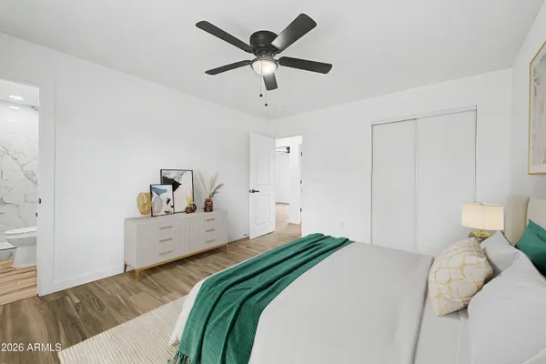 an empty room with wooden floor ceiling fan and windows