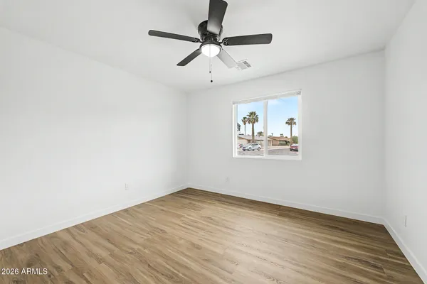 an empty room with a window and a ceiling fan