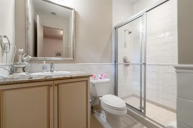 a bathroom with a granite countertop sink toilet and shower
