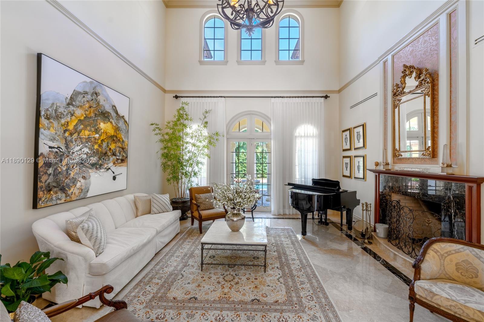 5785 Southwest 96th Street Pinecrest, FL 33156 - Photo 7 of 34 a living room with furniture a fireplace and a large mirror with potted plants