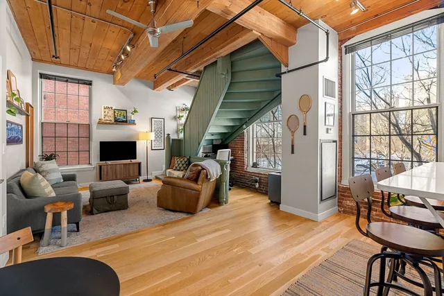 a living room with furniture fireplace and a large window