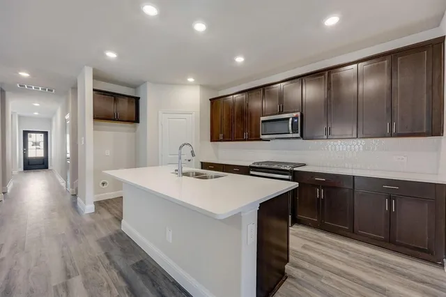 a kitchen with stainless steel appliances granite countertop counter space a sink cabinets and wooden floor
