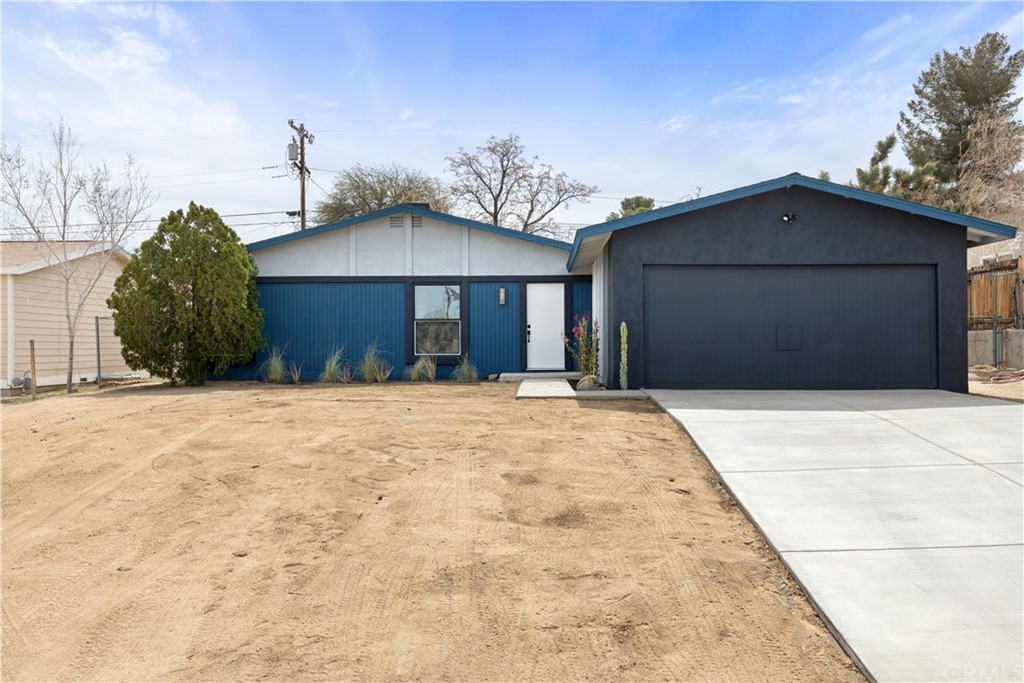 61589 El Reposo Street Joshua Tree, CA 92252 - Photo 15 of 15 a front view of a house with a yard and garage