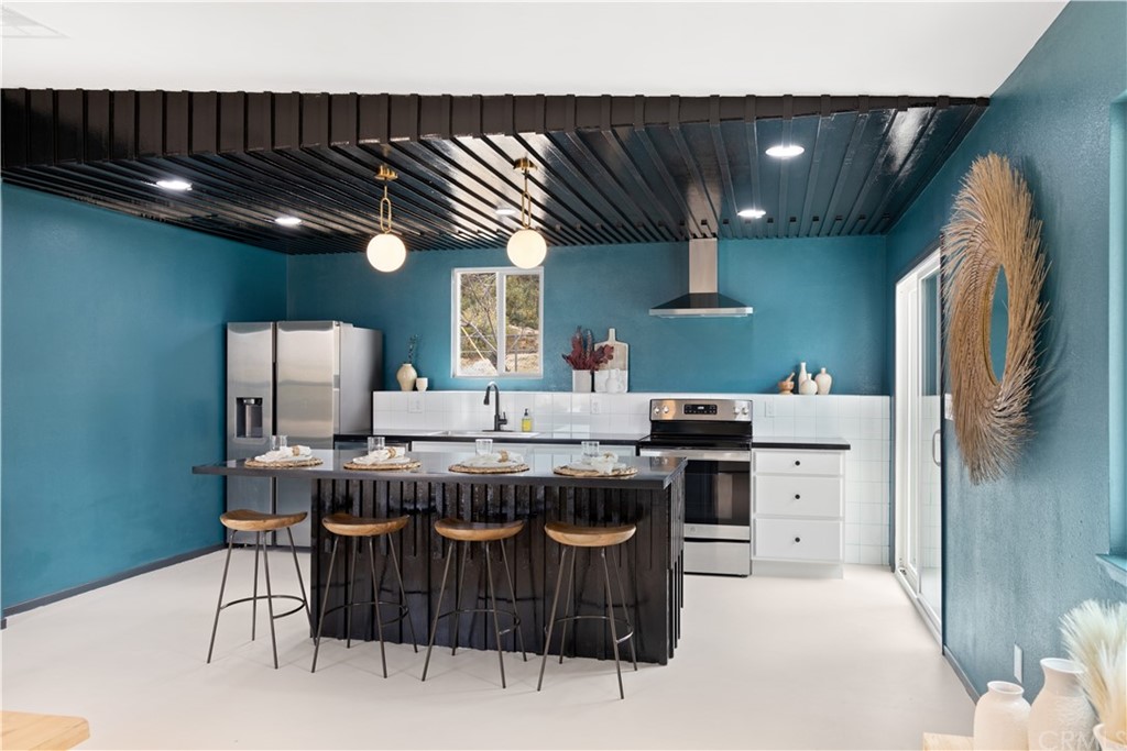 61589 El Reposo Street Joshua Tree, CA 92252 - Photo 6 of 15 a kitchen with stainless steel appliances granite countertop a stove a sink dishwasher and a refrigerator