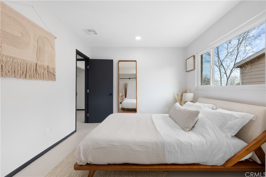 61589 El Reposo Street Joshua Tree, CA 92252 - Photo 8 of 15 a bedroom with a bed and wooden floor