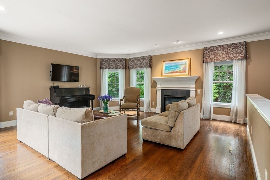 96 Beard Way Needham, MA 02492 - Photo 12 of 39 a living room with furniture a flat screen tv and a fireplace