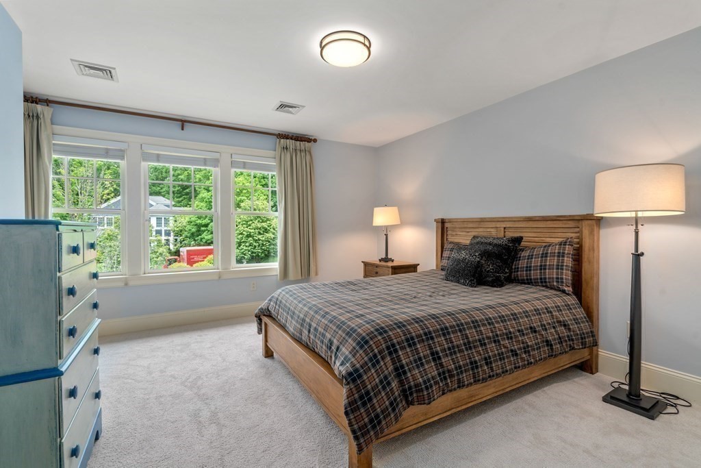 96 Beard Way Needham, MA 02492 - Photo 25 of 39 a bedroom with a large bed and a lamp next to a window