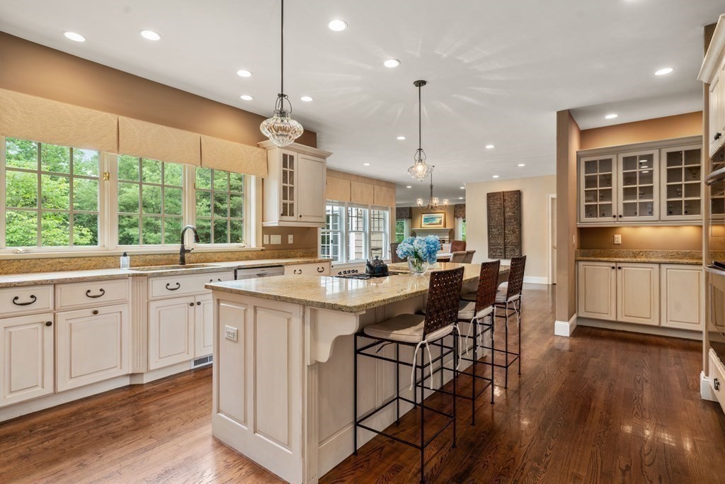96 Beard Way Needham, MA 02492 - Photo 8 of 39 a kitchen with stainless steel appliances granite countertop wooden floor dining table and chairs