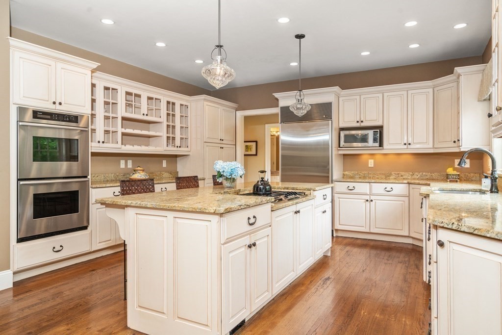 96 Beard Way Needham, MA 02492 - Photo 9 of 39 a kitchen with stainless steel appliances granite countertop a stove top oven a sink dishwasher and a refrigerator with wooden floor