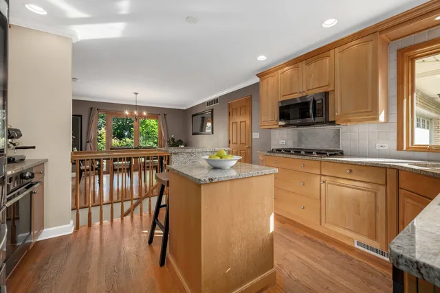 a kitchen with granite countertop a stove a sink and a microwave