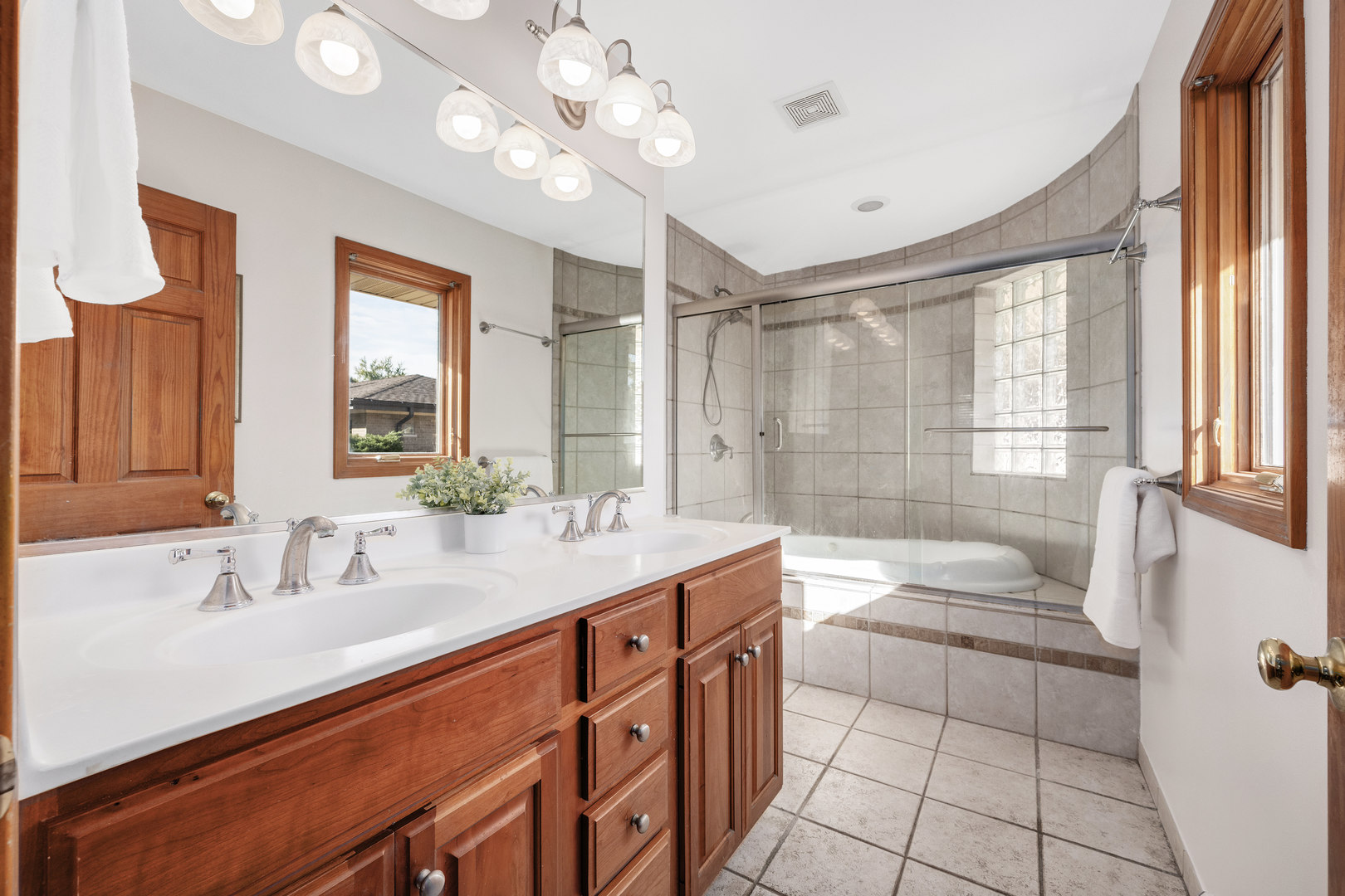 5305 Howard Avenue Western Springs, IL 60558 - Photo 17 of 35 a bathroom with a double vanity sink a toilet a mirror and shower