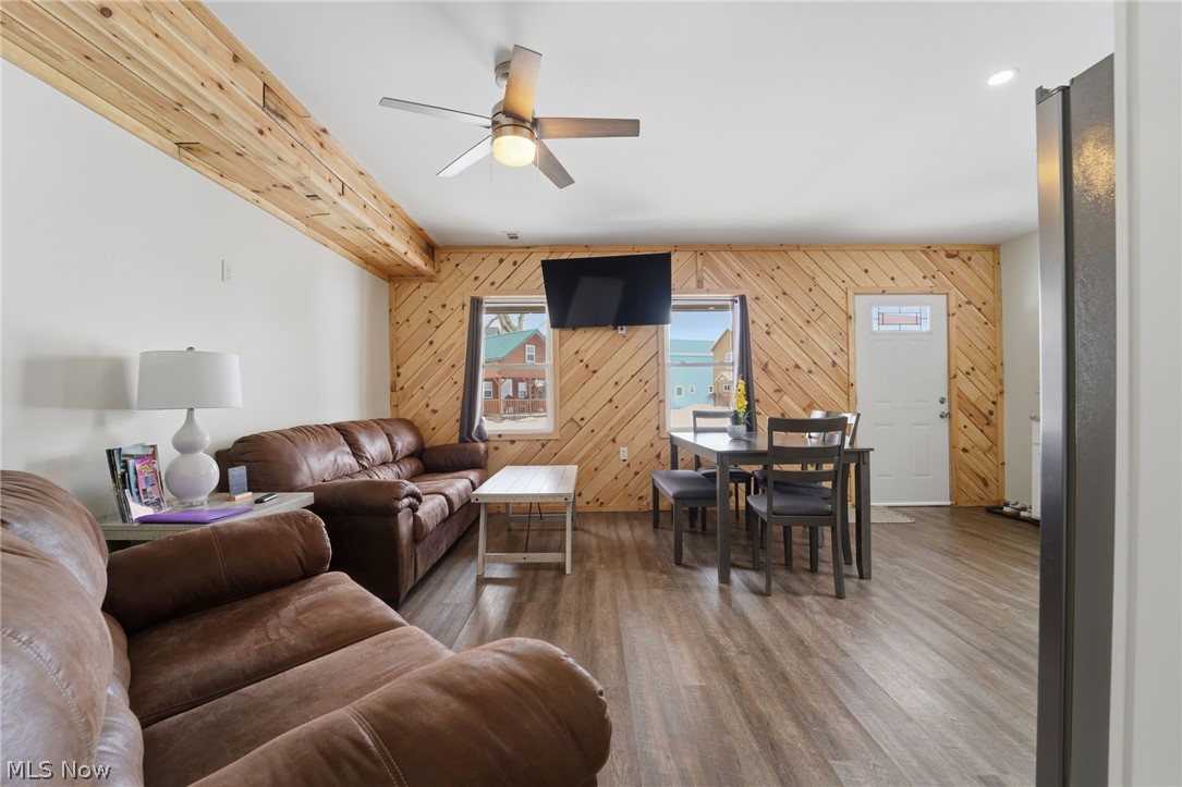 5919 Lake Road West, Unit 32 Ashtabula, OH 44004 - Photo 4 of 23 Living area featuring wooden walls, ceiling fan, and wood finished floors